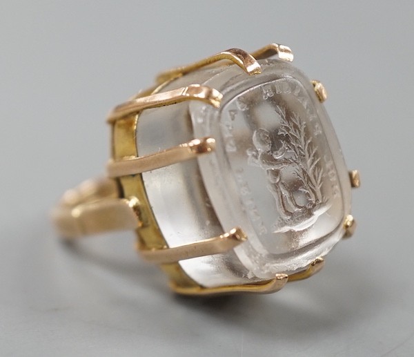 A modern 9ct gold ring, set with earlier oval rock crystal intaglio, the matrix carved with crest and the motto 'Nul Plaisir Sans Peine' size F, gross weight 10.7 grams.